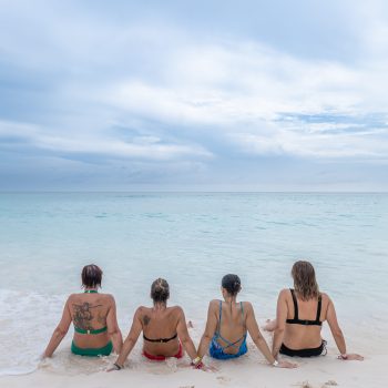 Group of women sitting in the shallow water of Saona’s natural pool