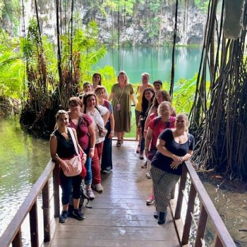 Group of tourists entering the wooden walkway to Los Tres Ojos cave park