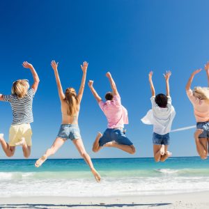 Group at the beach happy and jumping