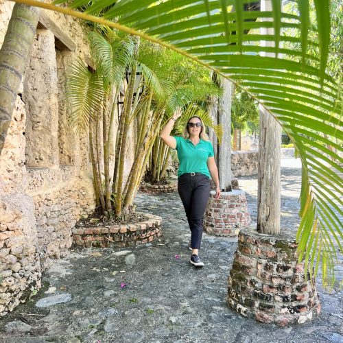Femme qui marche dans une ruelle sous les palmiers
