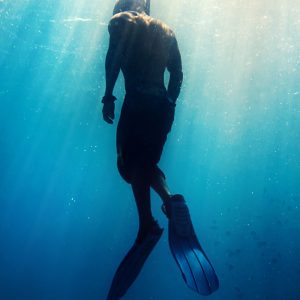 Diver swimming through clear waters near Saona