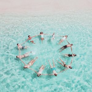Un groupe de voyageur forme un cercle dans l'eau turquoise