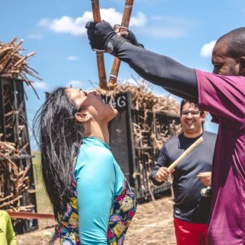 Local showing tourists how to taste raw sugarcane during the excursion
